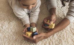 woman playing with number blocks with child